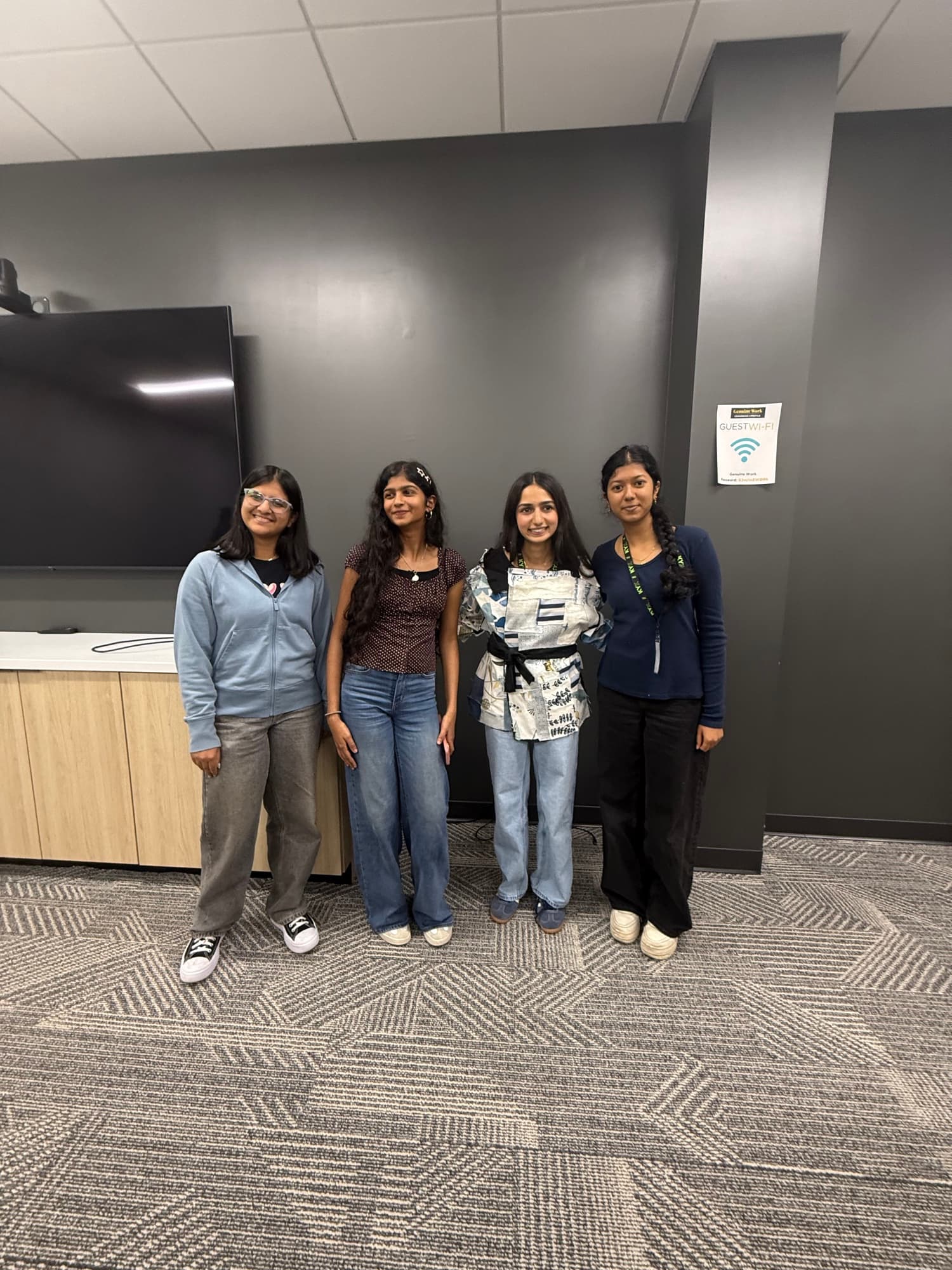 Four students pose with a garment they designed at Hack the Track 2026