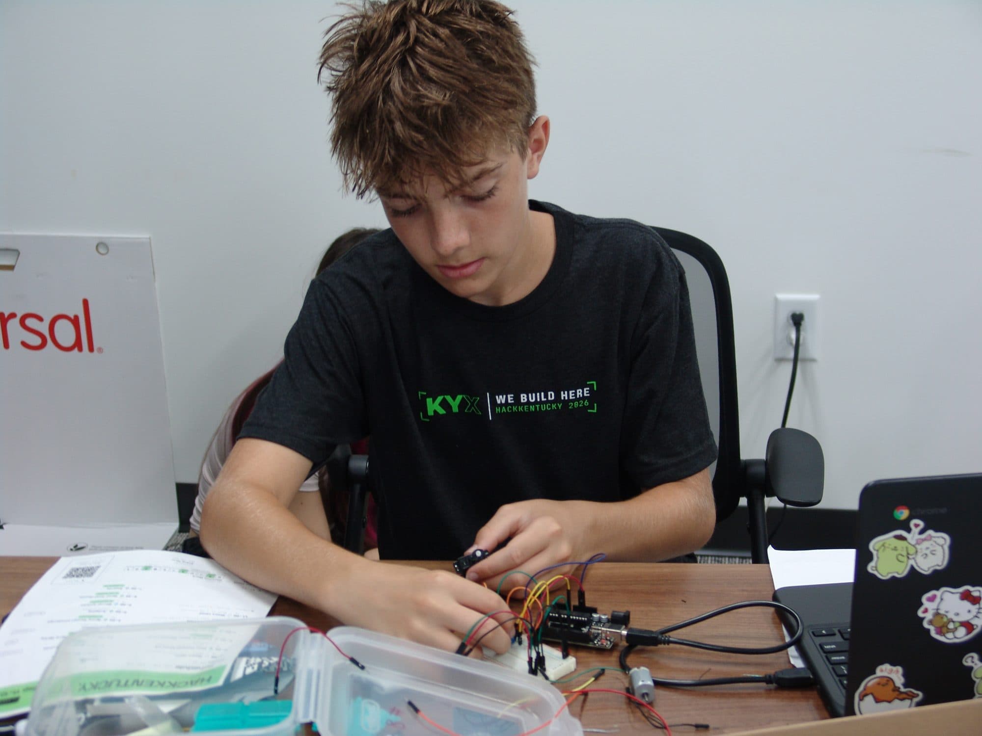 A student wiring an Arduino breadboard during the hardware track at Hack the Track 2026