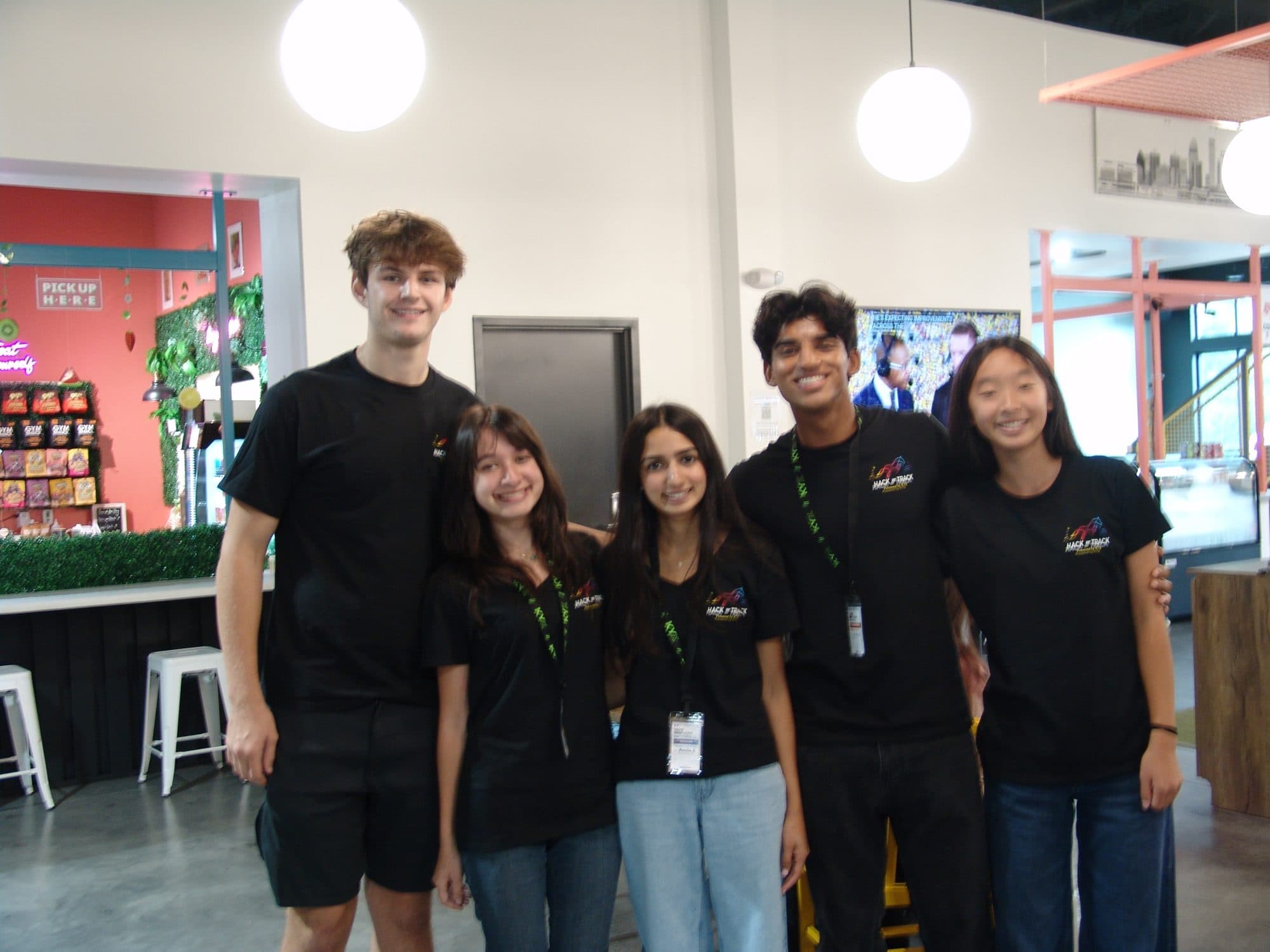 The Hack the Track 2026 student organizing team in matching black shirts at Genuine Work