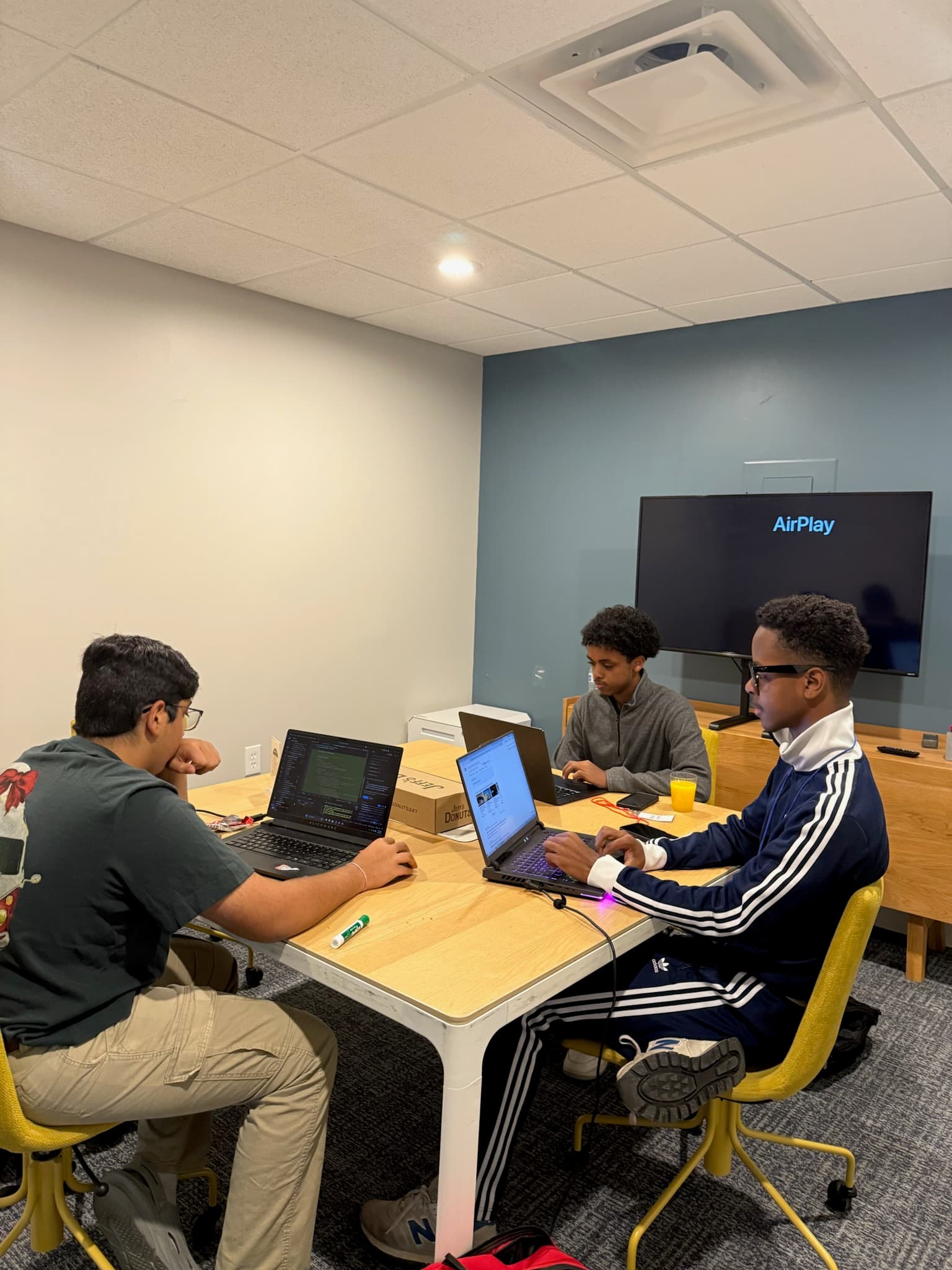 Three Hack the Track students working together on their project